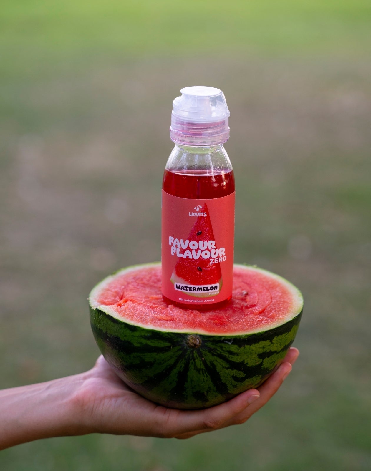 LiqVits FavourFlavour Sirup Konzentrat zuckerfrei Natürliches Aroma Watermelon Lifestyle Bild mit Sirup auf einer halben Wassermelone stehend