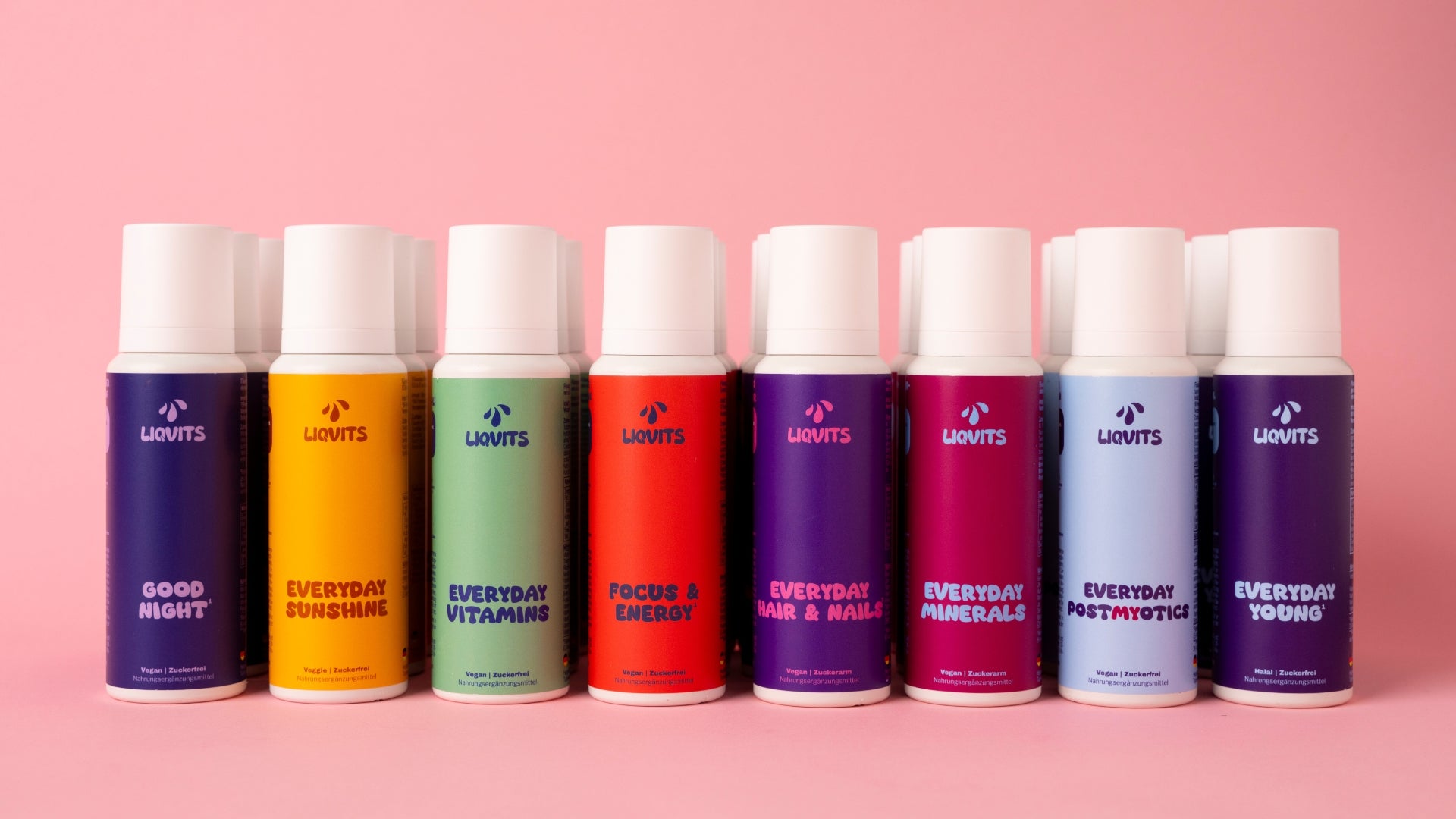 Alle LiqVits Flaschen mehrfach hintereinander und nebeneinander aufgereiht auf rosanem Hintergrund