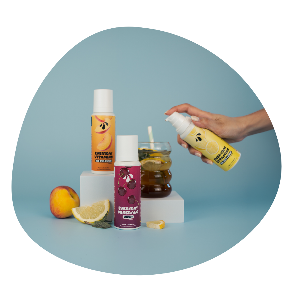 Foto von mehreren LiqVits Nahrungsergänzungsmitteln wobei ein Glas mit Everyday Vitamins - Ice Tea Lemon gefüllt ist und die Anwendung zeigt